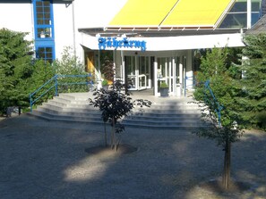 A building with a sign that reads 'Blickwinkel' and a set of stairs leading to the entrance.