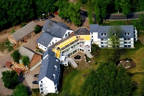 A multi-story building with a central courtyard, surrounded by parking and greenery. - Fährkrug (Templin)