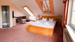Un dormitorio con una cama grande, un tragaluz, un sofá y una ventana.
