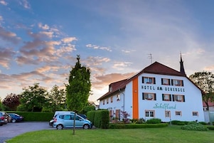 Un edificio de hotel con un letrero que dice 'HOTEL AM UCKERSEE' y 'Schilfland' en el costado.