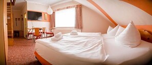 A hotel room with a bed, a desk, a chair, a TV, and a window. - Hotel Am Uckersee (Nordwestuckermark)