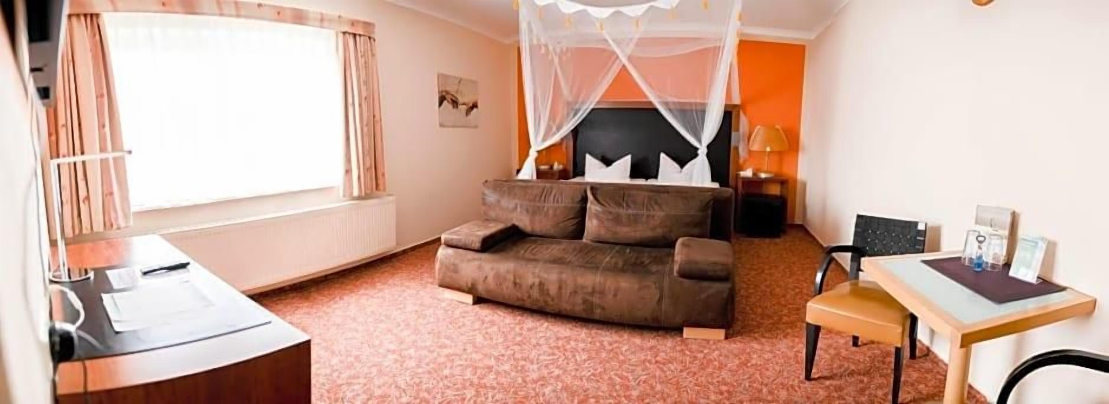 Ein Schlafzimmer mit einem Bett, einem Schreibtisch, einem Stuhl und einem Fenster.