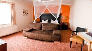 Un dormitorio con cama, escritorio, silla y ventana.