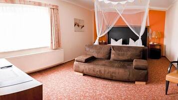 Ein Zimmer mit Bett, Schreibtisch, Stuhl, einem Fenster mit Vorhängen und einem Wandbild.