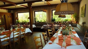 Un restaurant avec de nombreuses tables, des chaises et un long comptoir.