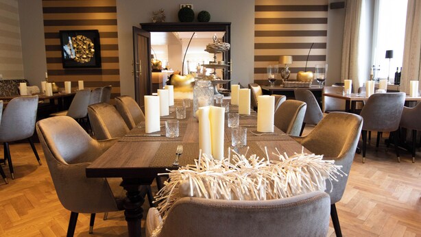 A dining area with a long table set for multiple people, surrounded by chairs. - Hotel Restaurant Hackmann-Atter (Osnabrueck)