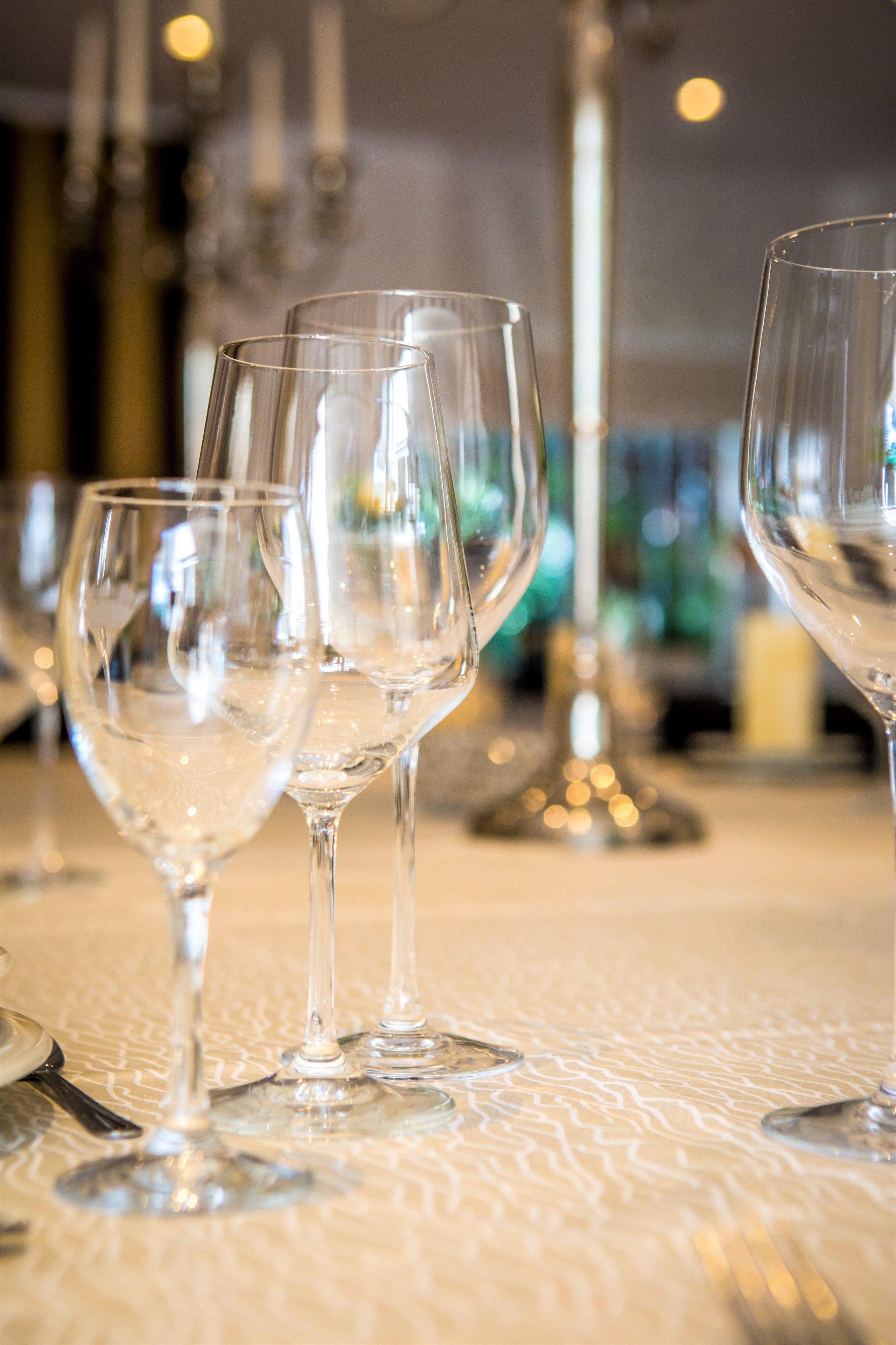 A table with several empty wine glasses and forks, suggesting a dining setting.