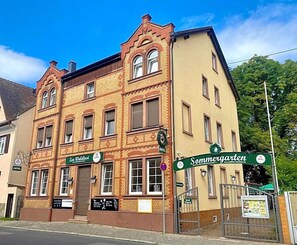A two-story building with a sign for 'Sommergarten' and a 'Hotel' sign.