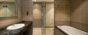 Ein modernes Badezimmer mit einer Duschkabine, einem weißen Waschbecken und einer Badewanne.