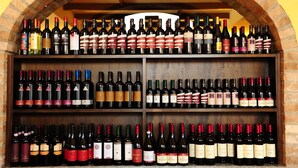 A wine rack with multiple shelves containing various bottles of wine. - Il Carrettino Country Hotel (Tortona)