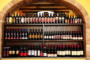 A wine rack with multiple shelves containing various bottles of wine. - Il Carrettino Country Hotel (Tortona)