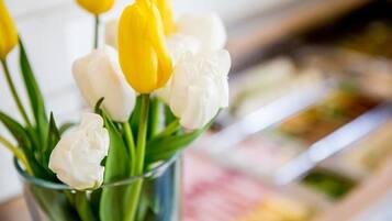 Un ramo de tulipanes amarillos y blancos en un florero de vidrio transparente.