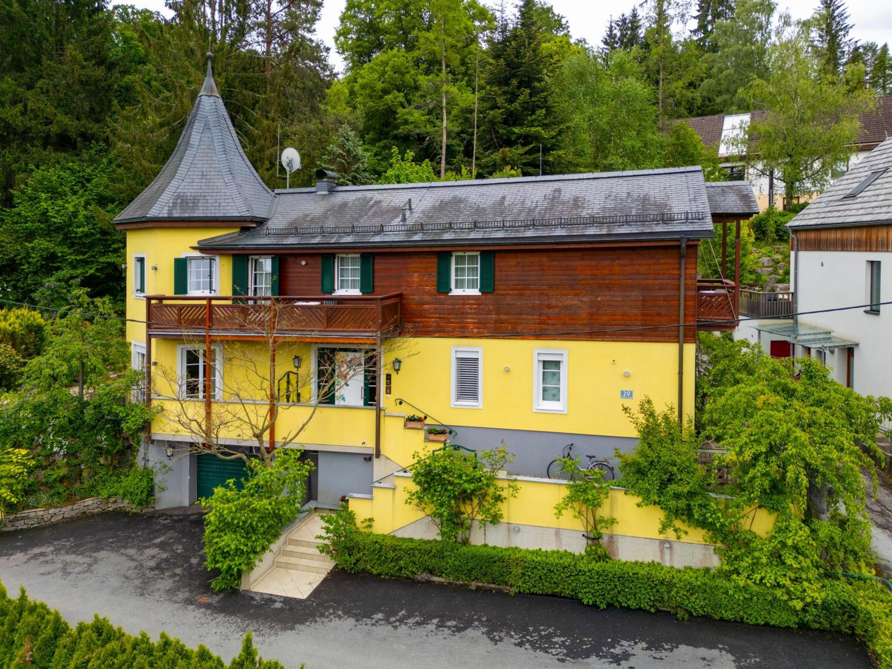 Ein zweistöckiges Gebäude mit einem steilen Satteldach, einem Balkon und einer kleinen Treppe, die zum Eingang führt.