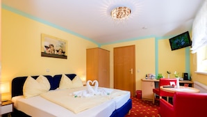 A hotel room with a bed, a desk, a chair, a television, and a painting on the wall. - 1a Hotel Steiner (Judenburg)