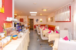 A hotel dining area with tables set for breakfast, a coffee station, and a buffet with various food items. - 1a Hotel Steiner (Judenburg)