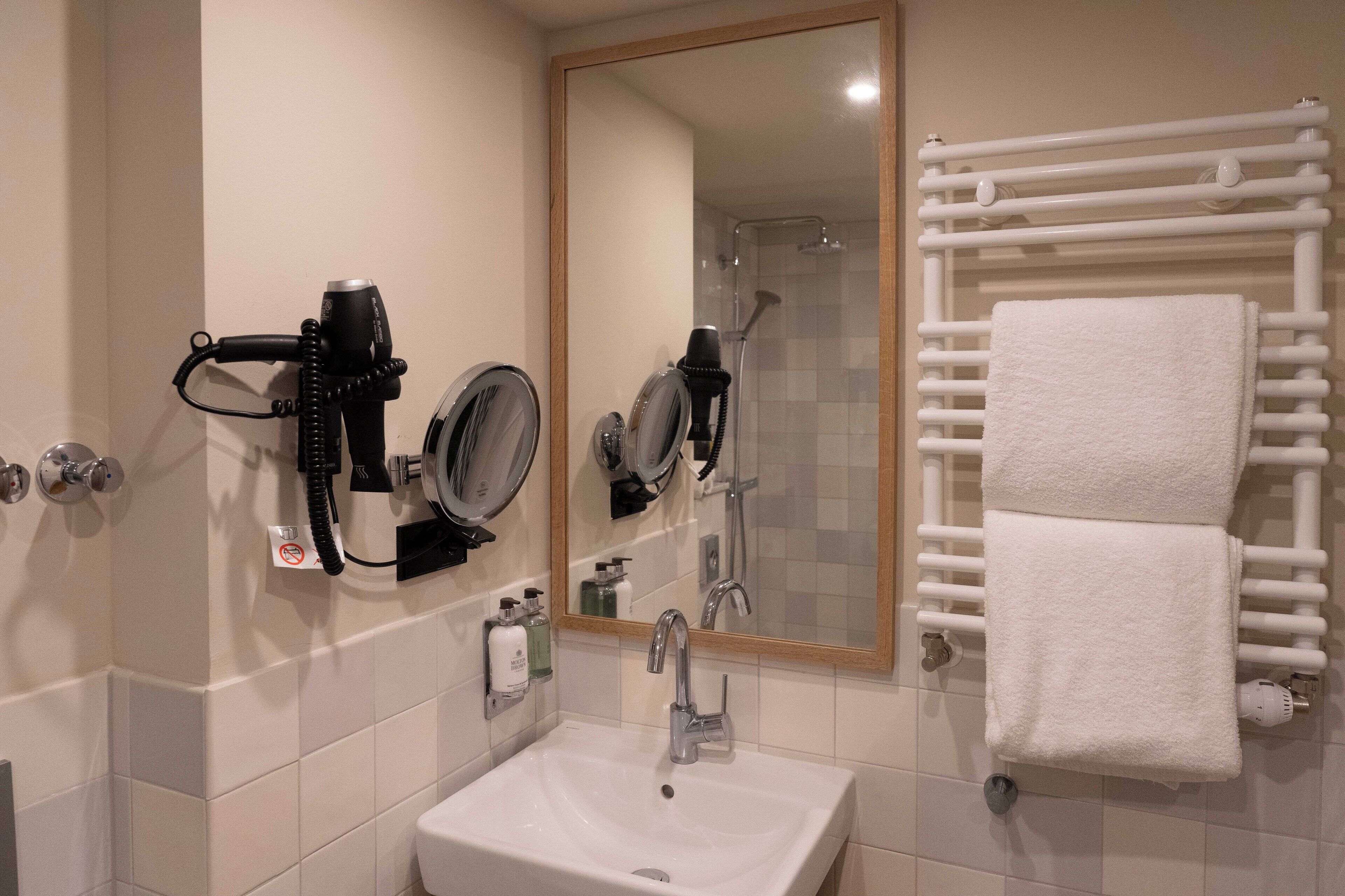 Ein Badezimmer mit Waschbecken, Spiegel und Handtuchhalter.