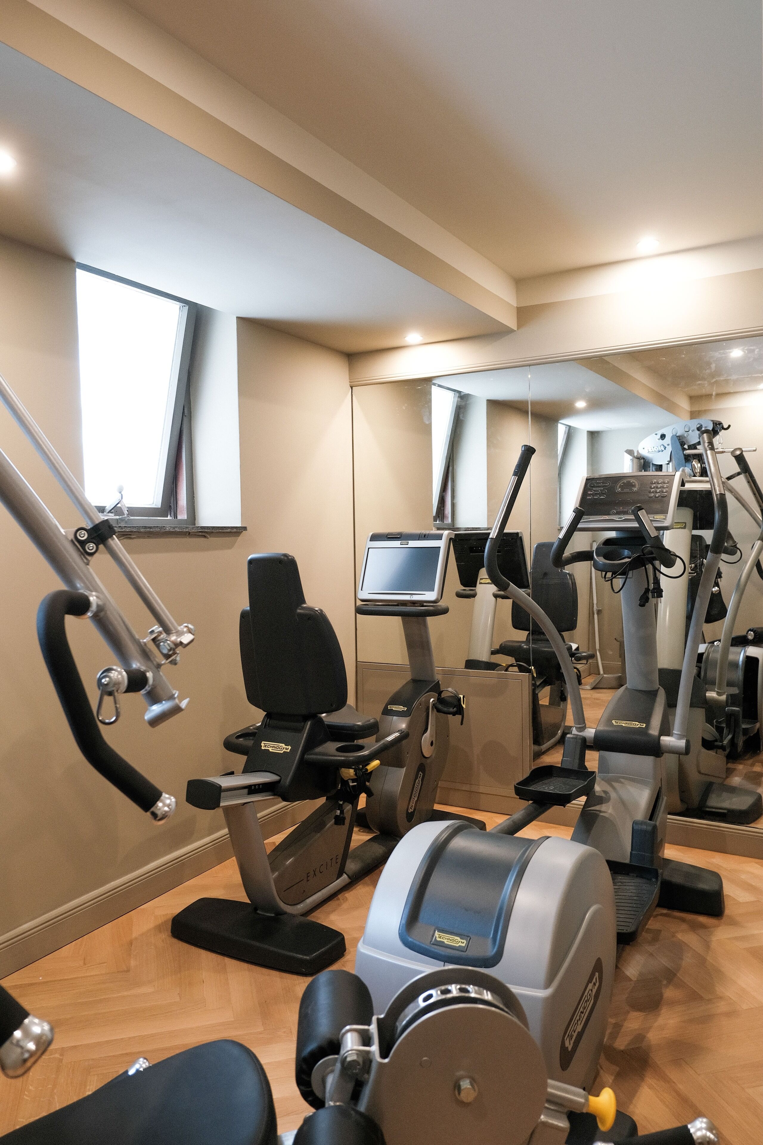 A gym with cardio machines, a rowing machine, and a bench press.