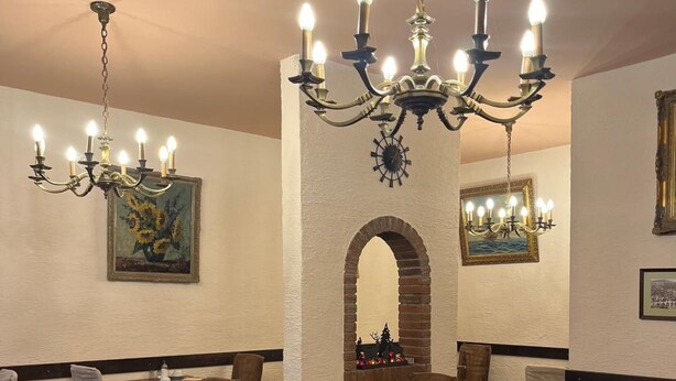 A restaurant interior with multiple tables and chairs, a chandelier, and framed artwork on the walls. - Hotel Vier Jahreszeiten (Heidelberg)