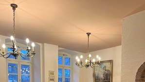 A restaurant with multiple tables and chairs, chandeliers, and a large window with a view. - Hotel Vier Jahreszeiten (Heidelberg)
