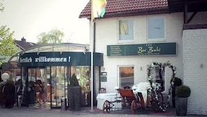 A building with a sign reading "Bei Baki" and a welcoming sign above the entrance. - Hotel & Restaurant Bei Baki (Sehnde)