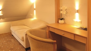 A small, cozy room with a bed, a chair, a desk, and a mirror. - Hotel & Restaurant Bei Baki (Sehnde)