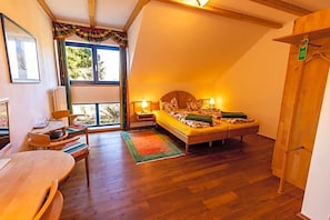 A bedroom with a bed, bedside tables, a window, and a wooden door.