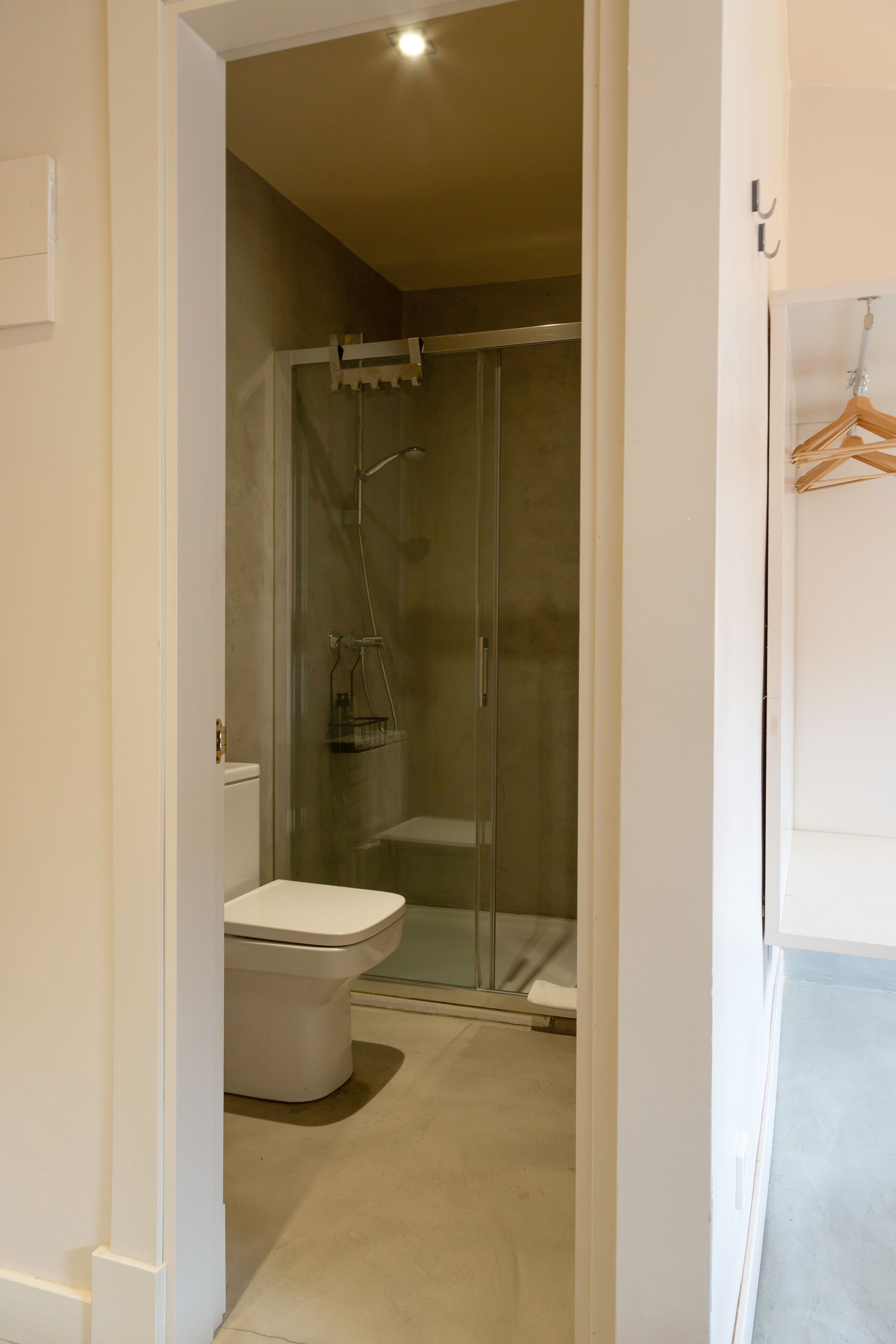 Ein Badezimmer mit Toilette, einer gläsernen Duschkabine und einem weißen Waschbecken.