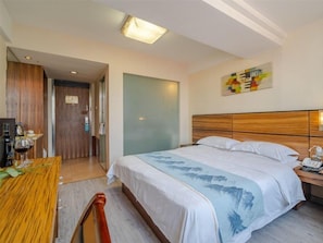 Una habitación de hotel con una cama, una mesita de noche y un escritorio con silla.