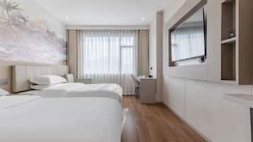 A hotel room with two beds, a desk, a chair, a TV, and a large window with curtains.