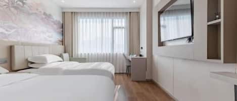 A hotel room with two beds, a desk, a chair, a TV, and a large window with curtains.