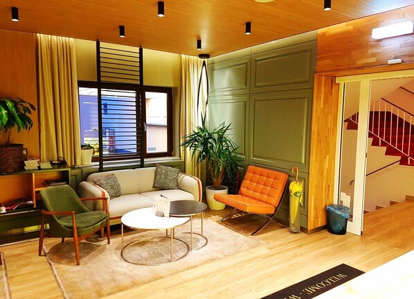 A modern living room with a sofa, chairs, a coffee table, and a potted plant. - St. Joseph Hotel (Hamburg)