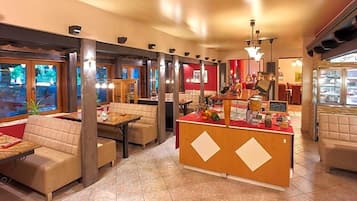 Een restaurantinterieur met zitjes, een balie en uitzicht op het omliggende landschap.