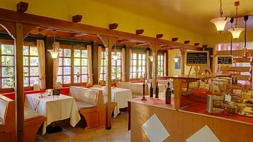 Een restaurant met houten zitjes, tafels en een bar.