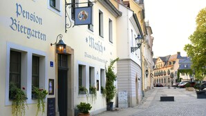 A street with buildings, including a Pension Biergarten and a Matich establishment.