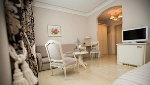 A hotel room with a bed, a chair, a small table, a TV, and a wardrobe. - Burghof (Hof)