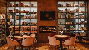Una biblioteca acogedora con estanterías, chimenea y asientos cómodos.