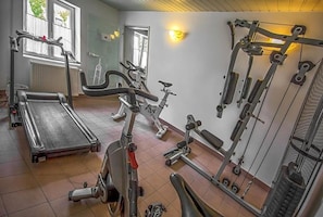 A gym with treadmills, stationary bikes, and weightlifting equipment. - Hotel Adler (Ingolstadt)