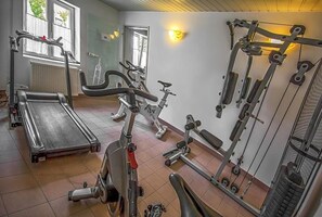 Un gimnasio con cintas de correr, bicicletas estáticas y equipos de levantamiento de pesas.