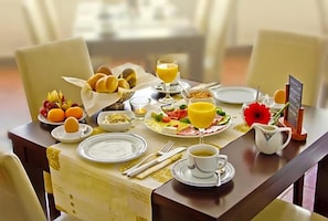 A breakfast table set with plates, bowls, a pitcher, and a menu.
