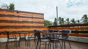 A terrace with wicker furniture and a wooden fence. - Sunset Stay Maldives (Thinadhoo)