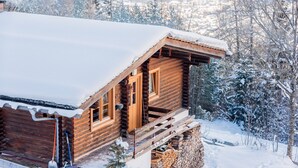 A log cabin with a wooden exterior, a porch, and a snow-covered roof. - Landgasthof Ropferhof (Telfs)