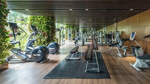 Une salle de sport équipée de divers appareils d’exercice, notamment des tapis de course, des vélos d’appartement et des appareils de musculation.