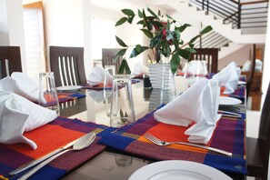 Enjoy a stylish meal in our elegantly set dining area, complete with a potted plant and modern amenities.