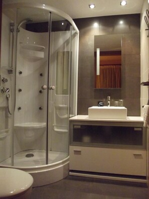 A modern bathroom with a glass-enclosed shower, a white sink, and a mirror above it. - Hostal Piteus (Sant Llorenc de Morunys)