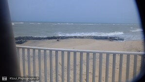Uitzicht op een strand met een railing op de voorgrond.