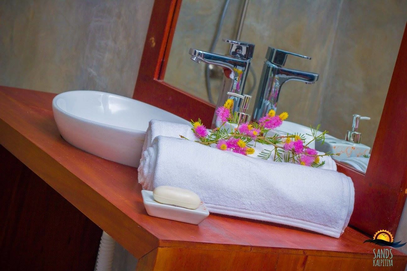 A bathroom with a white sink, a towel, and a soap dish.