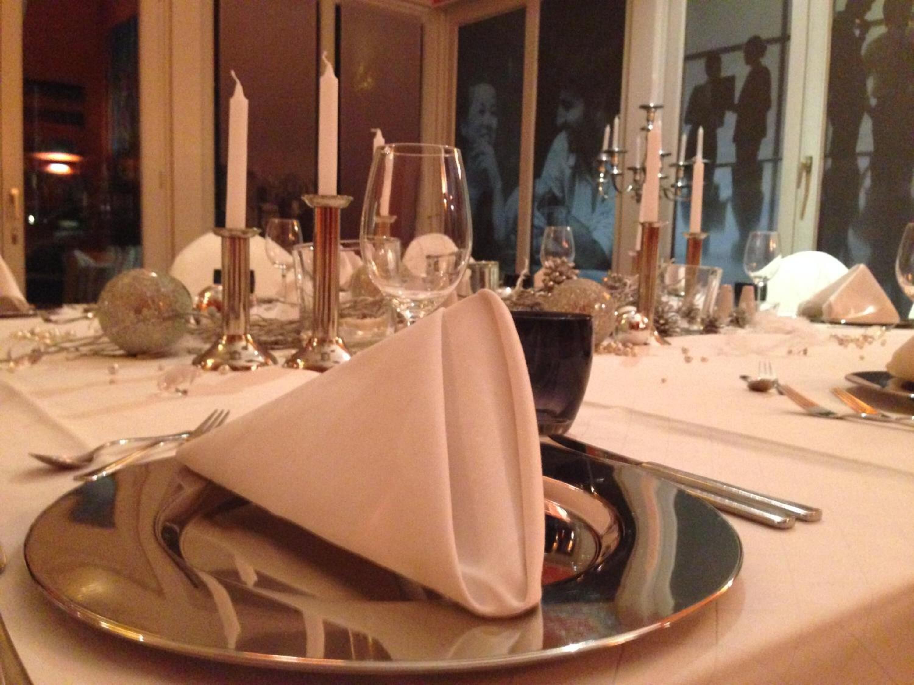 A table set for dining with a folded napkin, a black bowl, and various glassware.