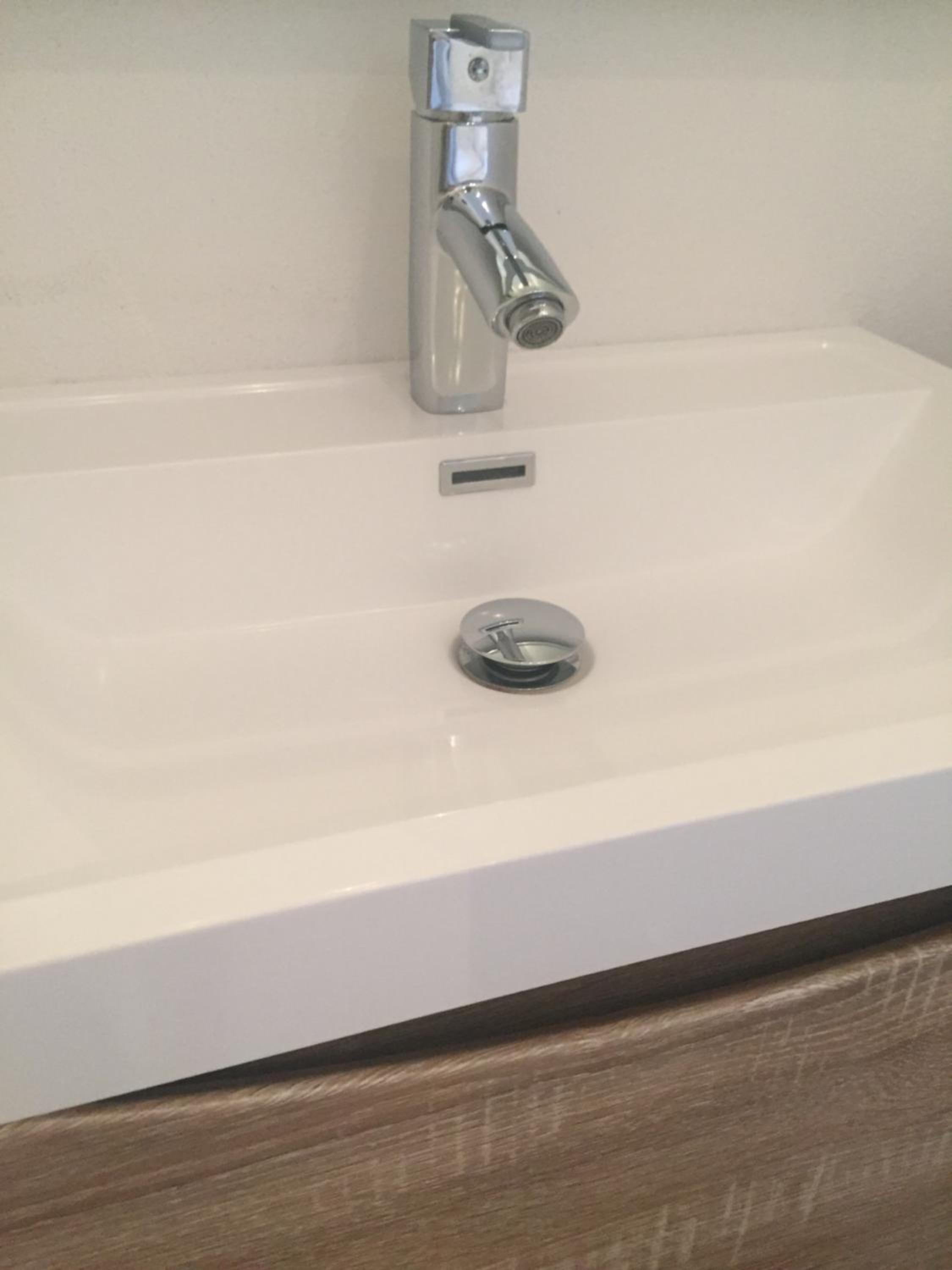 A bathroom sink with a chrome faucet and a single basin.