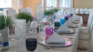 A dining table set with white napkins, silverware, and various glassware, including wine glasses and water glasses.