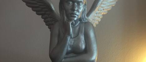 Una estatua de un ángel alado sentado sobre un pedestal.